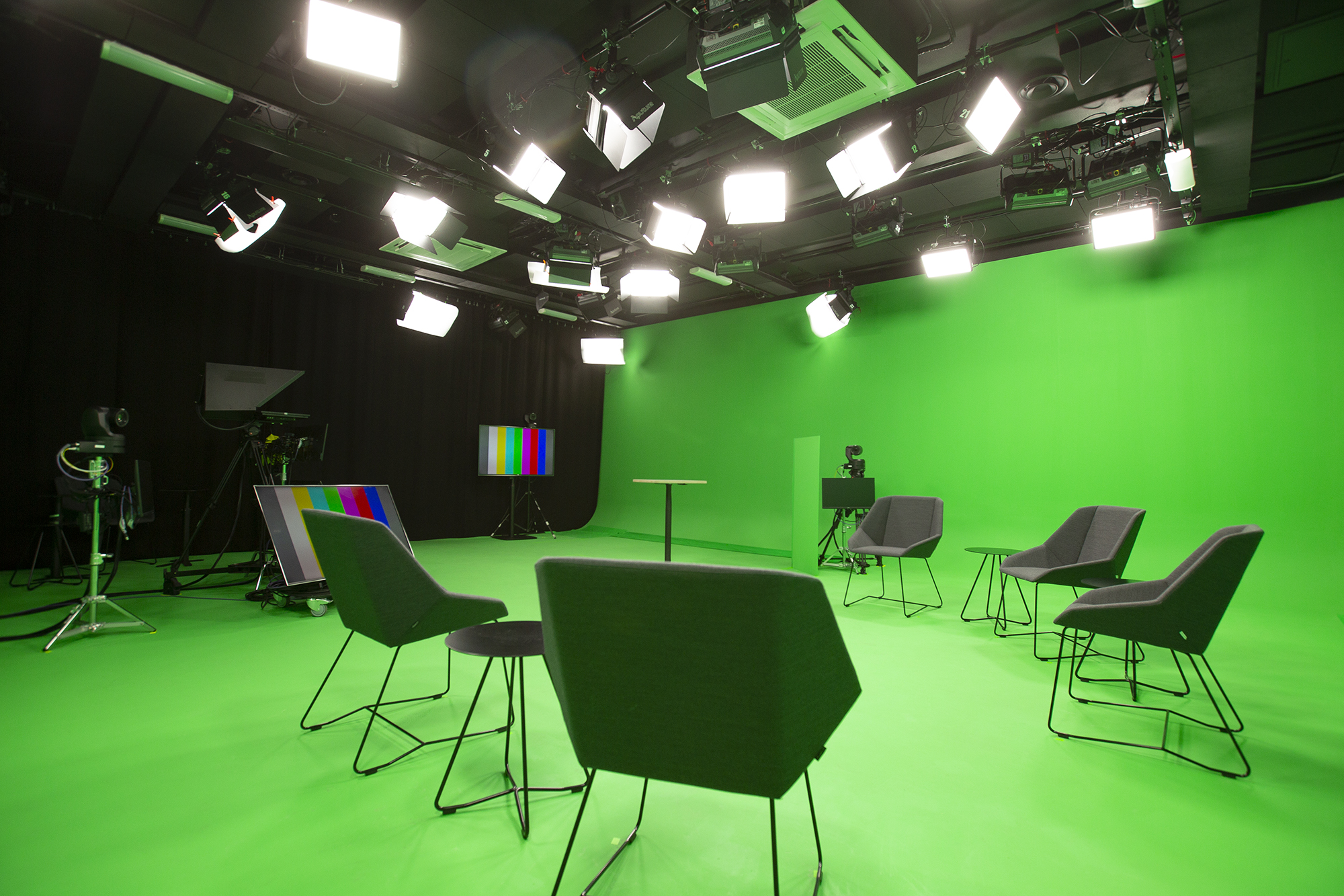 Green screen -studio: vihreä lattia ja tuolit valmiina kuvauksiin